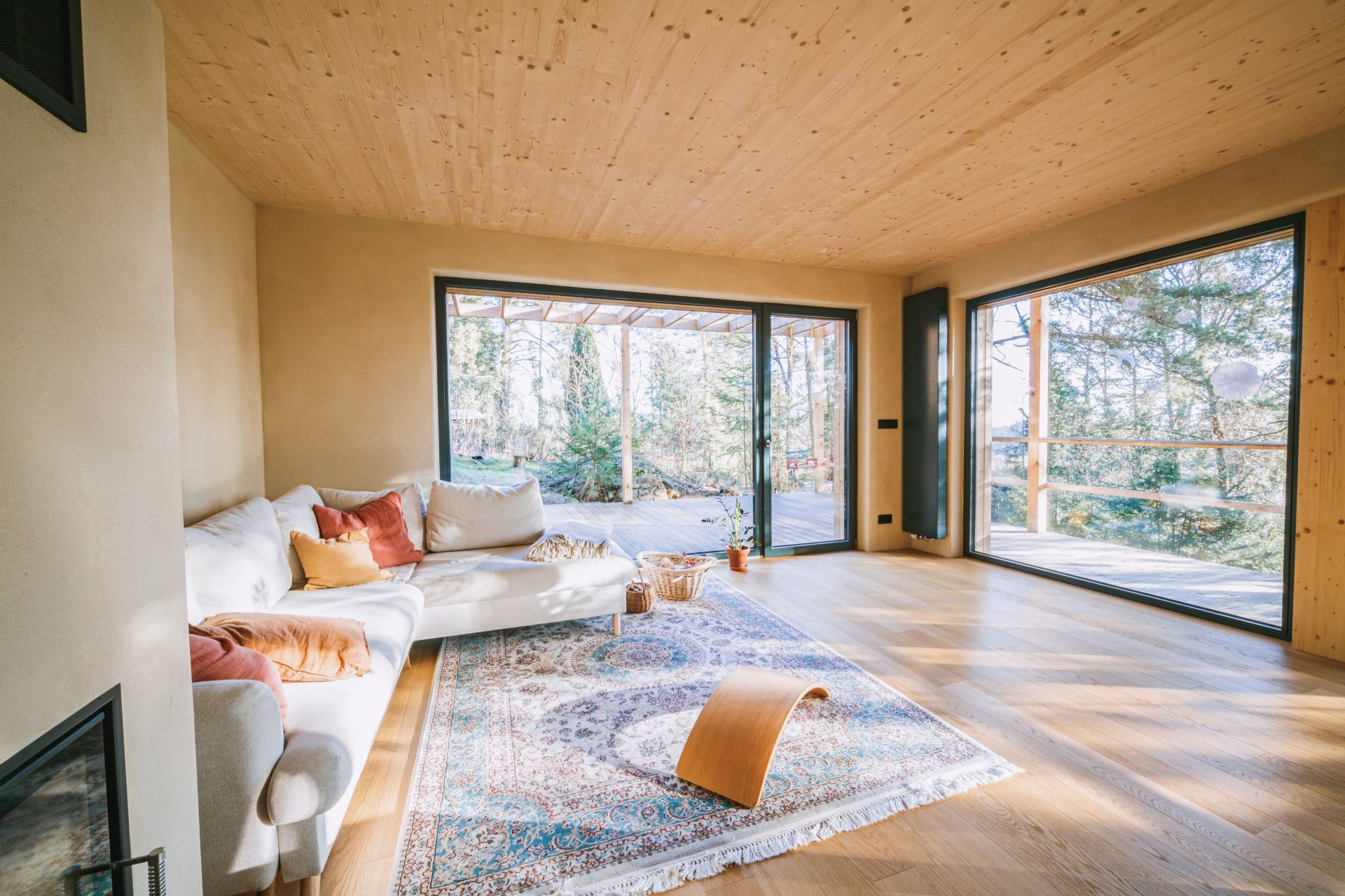 Helles Wohnzimmer mit modernem Design, großen Fenstern und gemütlichen Möbeln.